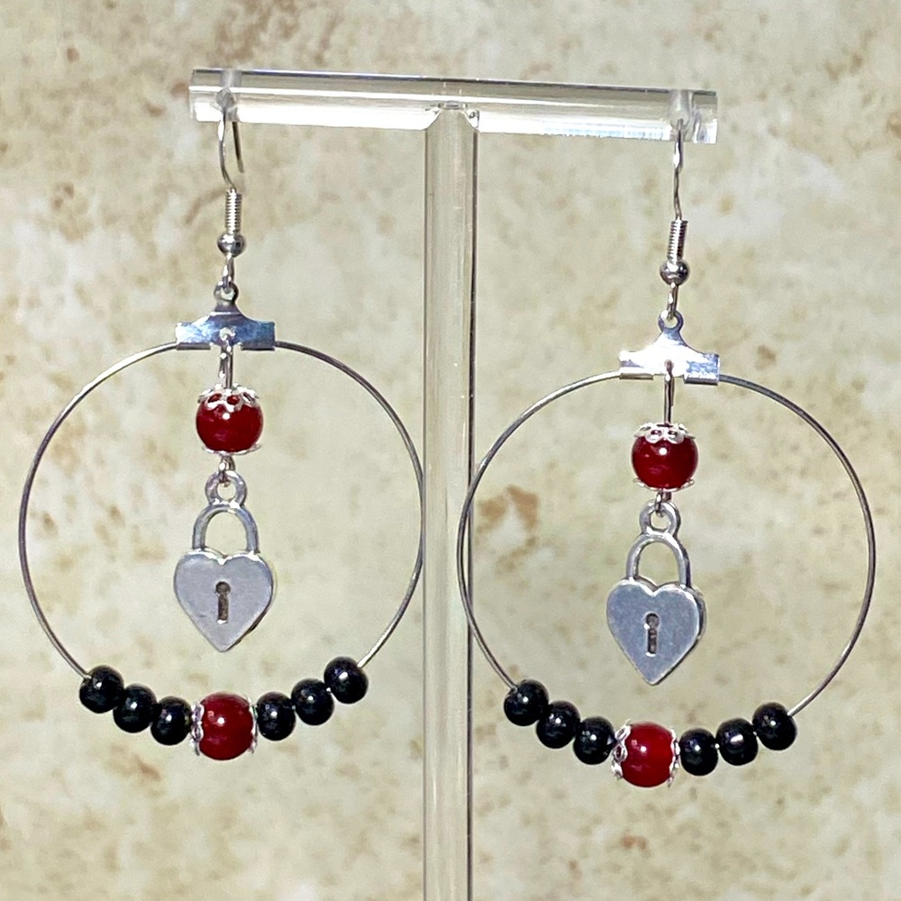 Silver tone hoop earrings with obsidian and red beads with lock charm